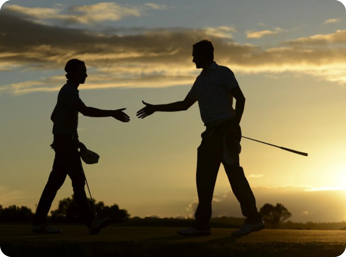 Silhouette of golfers with sunset backdrop